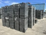 Paleta rectangular plana de fibra de vidrio color negro, de 850 x 450 x 20 mm, usada como bandeja en maquinas de fabricacion de bloques y adoquines — Cuarta vista: paletas de fibra de vidrio en uso o apiladas.